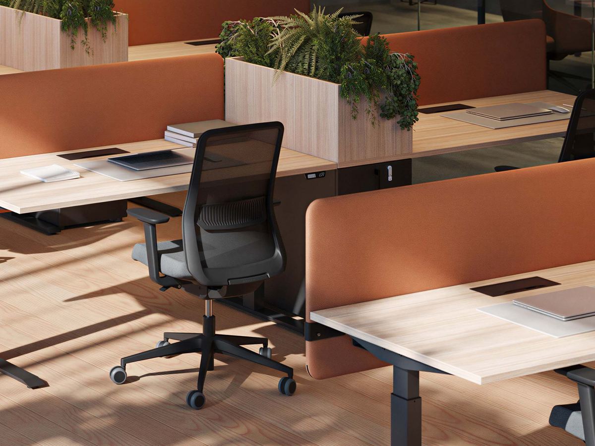 Kantoorwerkplekken met zit-stabureaus, bureaustoelen en oranje akoestische schermen